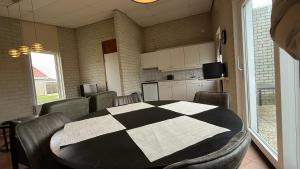 a room with a table and chairs and a kitchen at Bungalow Noordzee B in Julianadorp