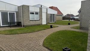 a brick walkway in front of a house at Bungalow Noordzee B in Julianadorp