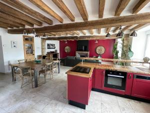 a kitchen and dining room with red cabinets and a table at Gîte La Nuit Étoilée chez Champagne Mathelin in Mareuil-le-Port