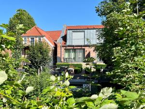 una casa con un jardín delante de ella en Haus am Siel 01, zentral mit eigenem Steg, en Greetsiel