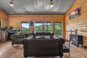 a living room with two couches and a stove at Ohio Starlight Glamping Cabins - A Peaceful Woodland Retreat 