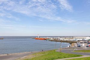 un muelle con coches estacionados junto al agua en Seeterrassen, FeWo 27, en Cuxhaven 2 fotos más