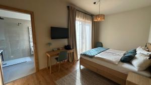 a bedroom with a bed and a desk and a window at Weinquartier - Weinrebenblick Kleindienst in Sankt Stefan ob Stainz