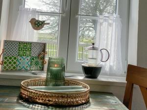 einen Tisch mit einer Glasvase und einem Fenster in der Unterkunft Appartement Huus Appelboom in Nordstrand + 11 Fotos