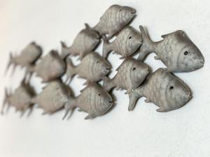 eine Gruppe von Angelhaken, die an einer Wand hängen in der Unterkunft Appartement Huus Appelboom in Nordstrand