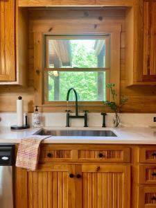 a kitchen with a sink and a window at Mossy Falls Cabin by Leavetown Vacations in Altamont +28 photos