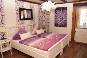 a bed with purple cushions in a room at Ferienhaus Herby in Bad Zwesten