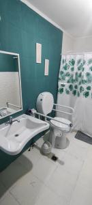 ein grünes Bad mit einem WC und einem Waschbecken in der Unterkunft Departamento para dos personas in Río Gallegos