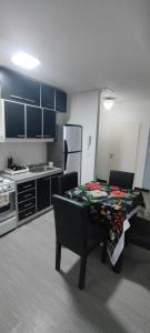 eine Küche mit einem Tisch in der Mitte eines Zimmers in der Unterkunft Departamento para dos personas in Río Gallegos