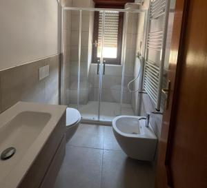 a bathroom with a shower and a toilet and a sink at Riaci Bay in Tropea