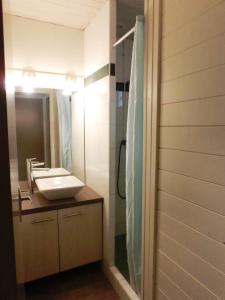 ein Badezimmer mit Waschbecken und Dusche mit Spiegel in der Unterkunft VVF Landes Moliets in Moliets-et-Maa + 23 Fotos