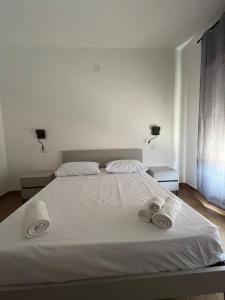 a bedroom with a white bed with two towels on it at Riaci Bay in Tropea
