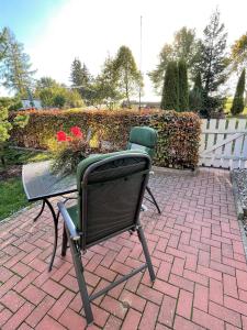 two chairs and a table on a brick patio at Neue moderne Ferienwohnung, separater Eingang, Seenähe in Möllen