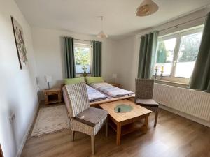 a living room with a bed and a table at Neue moderne Ferienwohnung, separater Eingang, Seenähe in Möllen
