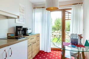 a kitchen with a glass table in front of a window at Strandhaus Claassen 02 in Ahrenshoop