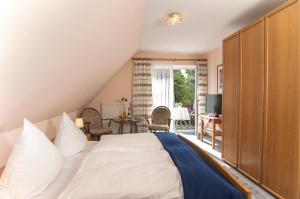 a bedroom with a large white bed and a table at Landgasthaus Zum Naturschutzpark in Bispingen