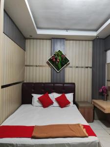 a bedroom with a large bed with red pillows at Angs residence in Surabaya +15 photos