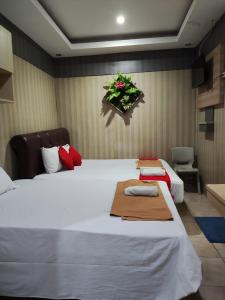a bedroom with a large white bed with a flower arrangement on the wall at Angs residence in Surabaya