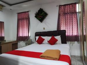 a bedroom with a large bed with red pillows at Angs residence in Surabaya