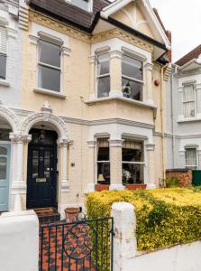 a house with a black door and a gate at Double bedroom in homely, 5 bedroom family house by the river in Fulham in London