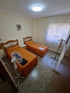 a room with two beds and a window at APARTAMENTO BEATRIZ 2 in Burriana