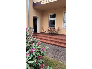a front porch of a house with pink flowers at KOS - Haus Netti in Koserow