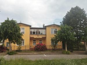 a yellow building with a fence in front of it at KOS - Haus Netti in Koserow