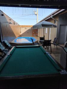 德尔菲诺波利斯Aconchego da canastra的后院的台球桌,配有遮阳伞
