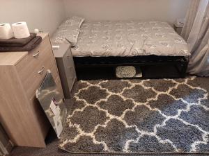 a bedroom with a bed and a rug and a dresser at Newly renovated & furnished luxury bedroom in Kirkliston