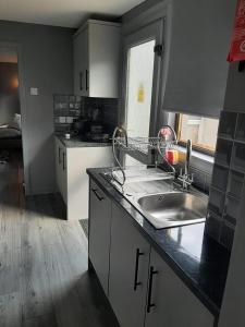 a kitchen with a sink and a counter top at Newly renovated & furnished luxury bedroom in Kirkliston