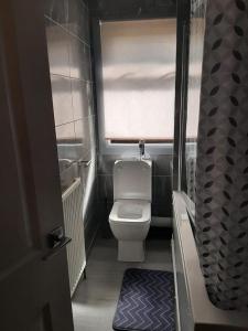a small bathroom with a toilet and a window at Newly renovated & furnished luxury bedroom in Kirkliston