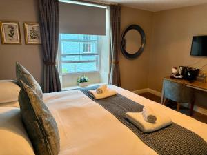 a bedroom with a bed with towels on it at The Queen's Head in Alnwick +29 photos