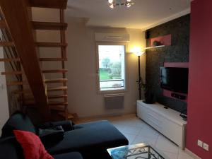 een woonkamer met een bank en een televisie bij Le centre historique au calme in Dinan