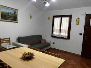 a living room with a table and a couch at La Borgata - Guest House in Campanedda