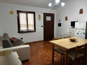 a living room with a table and a couch at La Borgata - Guest House in Campanedda