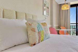 ein Schlafzimmer mit einem Bett und einem Kissen darauf in der Unterkunft Pink Surf by StayMareni - Oceanfront 2 Queens Suite in Myrtle Beach