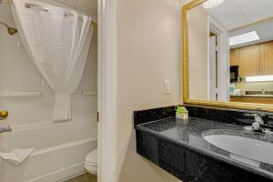 ein Badezimmer mit Waschbecken, Badewanne und Spiegel in der Unterkunft Pink Surf by StayMareni - Oceanfront 2 Queens Suite in Myrtle Beach