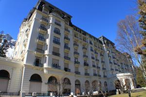 a large white building with trees in front of it at Apartment Majestic 1 in Chamonix-Mont-Blanc