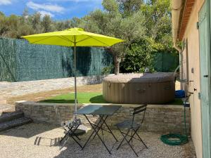 a yellow umbrella and two chairs and a table at Logement calme et chaleureux dans villa in Évenos +33 photos