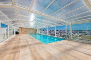 an indoor swimming pool in a large room with a large ceiling at Del Marina Apartment in Olhão
