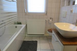 a bathroom with a sink and a tub and a toilet at Ferienwohnung Wilhelmine in Mosigkau +7 photos