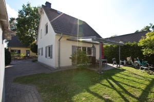 una pequeña casa blanca con techo inclinado en Ferienhaus Ahorn, en Göhren-Lebbin