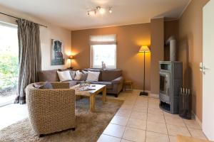 una sala de estar con un sofá y una mesa en Ferienhaus Ahorn, en Göhren-Lebbin 23 fotos más