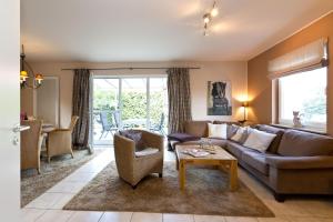 una sala de estar con un sofá y una mesa en Ferienhaus Ahorn, en Göhren-Lebbin