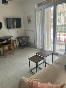 a living room with a couch and tables and a tv at Warm and fully equipped studio in Aubervilliers
