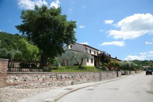 una calle con una pared de piedra y una casa en B&B Contarine, en Cinto Euganeo