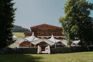 un grande edificio con tende bianche di fronte ad esso di Hotel Glemmtalerhof a Saalbach Hinterglemm