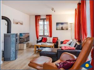 a living room with a couch and a tv at Haus Hornhecht in Kamminke