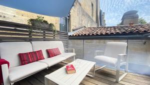 a balcony with a couch and two chairs and a table at Superbe Duplex en Hypercentre avec Rooftop et Climatisation in Bordeaux +6 photos