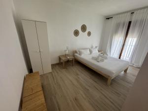 a white bedroom with a bed and a window at Casa Girasoles - Centro Campillos in Campillos